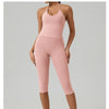 Eine Frau modelliert ein rosa Yoga-Activewear-Set für Damen, bestehend aus Tanktop und Leggings.