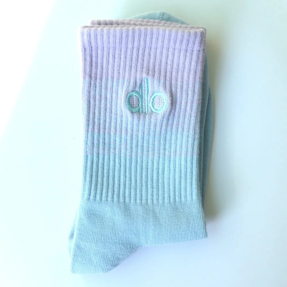 Light blue knitted socks with a small teal logo on the toe area