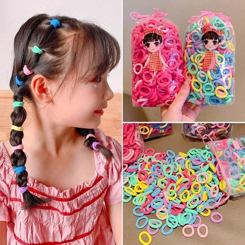 Ein Mädchen mit farbigen Nylon-Haargummis, die zur Herstellung von Pferdeschwänzen und Zöpfen verwendet werden.