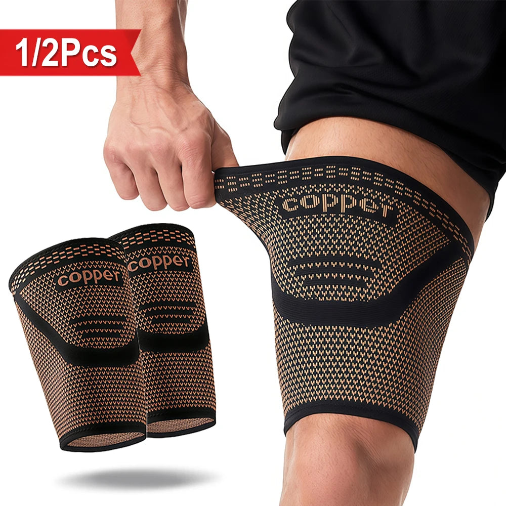 Pair of copper anti-slip thigh compression sleeves being held by a hand.
