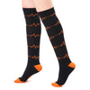 Black compression elastic socks with orange lightning bolt patterns on the calf and toe area.
