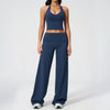A woman wearing a navy blue women's premium fitness tracksuit consisting of a sports bra top and matching long pants.