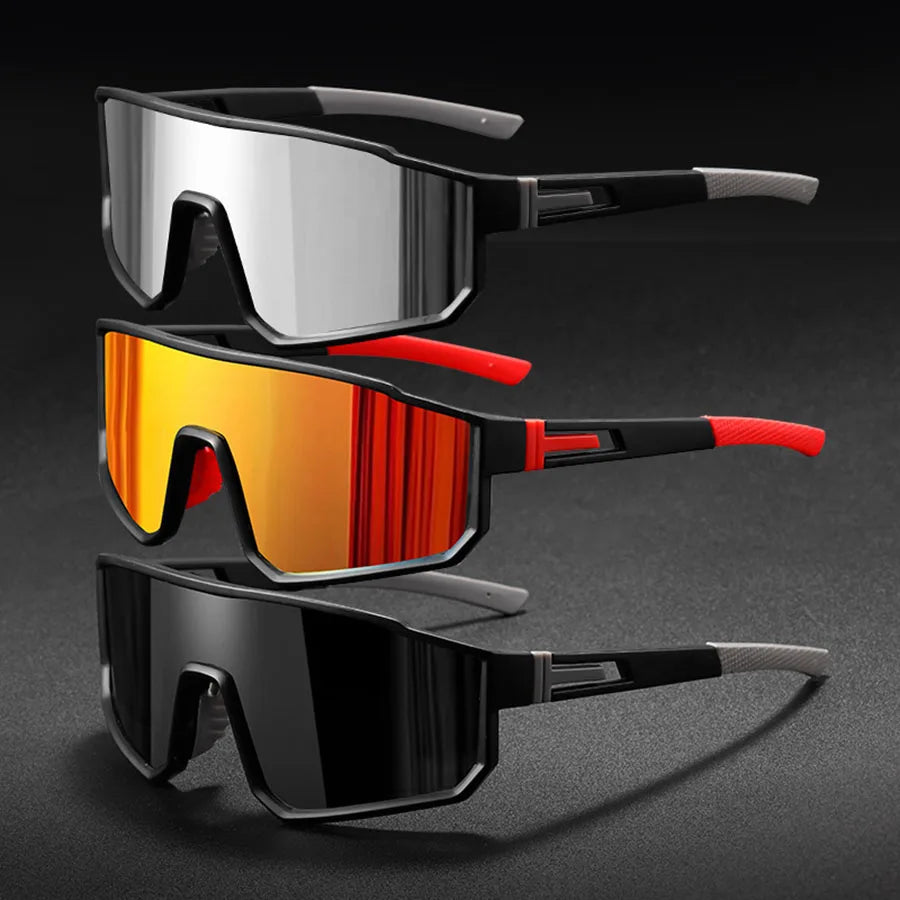 ثلاث نظارات شمسية كبيرة للقيادة بالدراجات للرجال باللون الفضي والبرتقالي والأسود معروضة على خلفية داكنة.