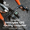 A close-up of a Rockbros intelligent GPS cycling computer mounted on a bicycle handlebar.