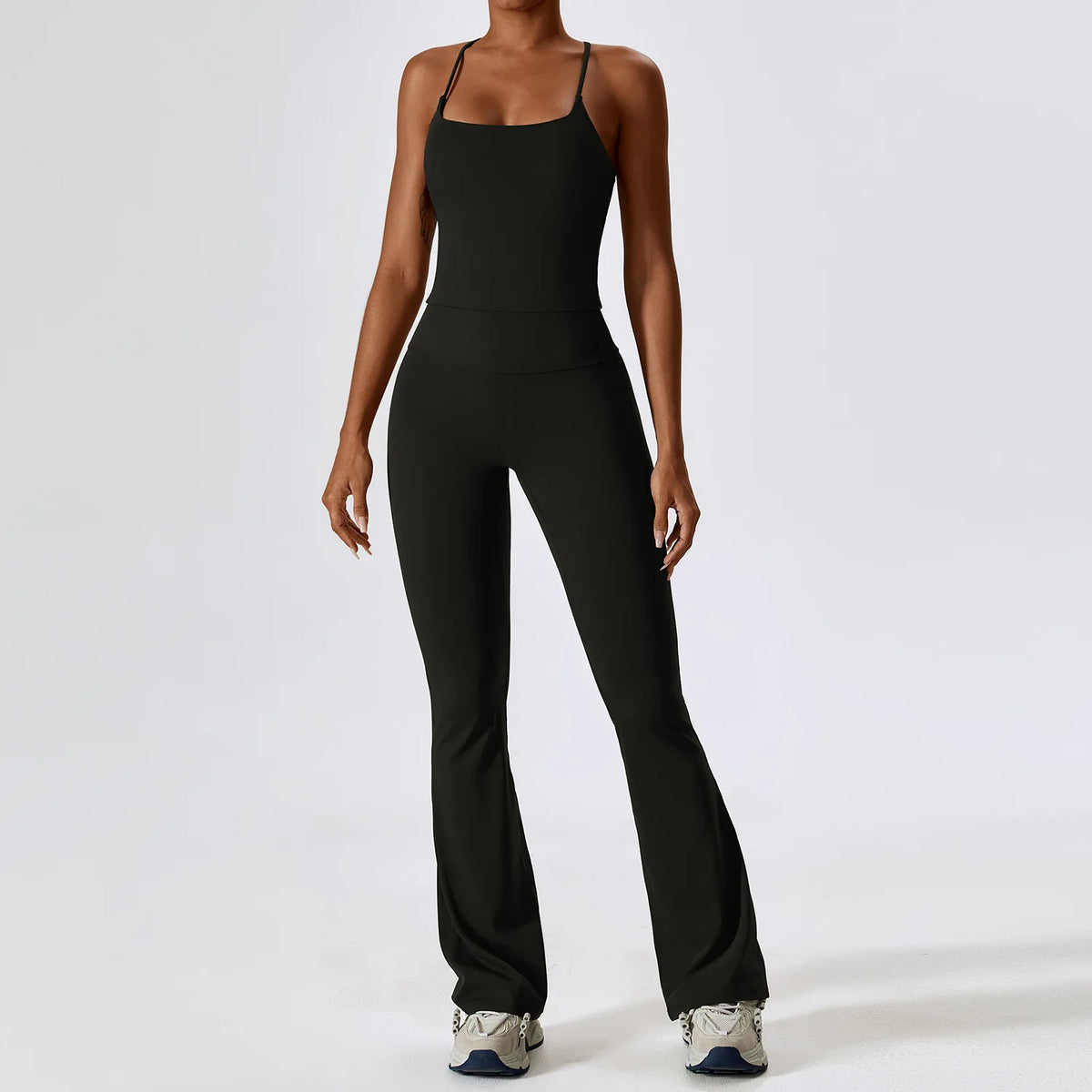 A woman wearing a black women's performance tracksuit set, consisting of a tank top and fitted pants.