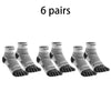 Six pairs of black and white five-finger compression socks laid out.