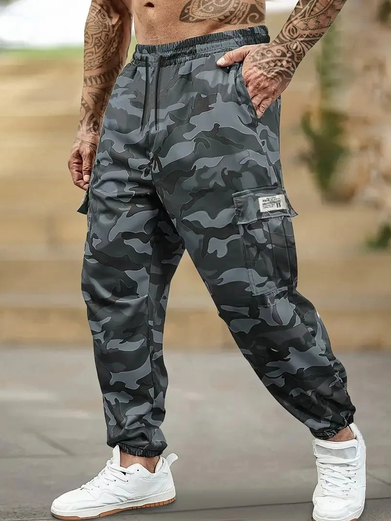 Un homme portant un pantalon cargo camouflage et des baskets blanches, montrant la coupe et les détails du vêtement.