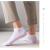 Ein Paar hellviolette Knöchelsocken, gezeigt neben Hosen.
