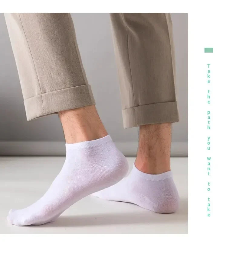 Ein Paar hellviolette Knöchelsocken, gezeigt neben Hosen.