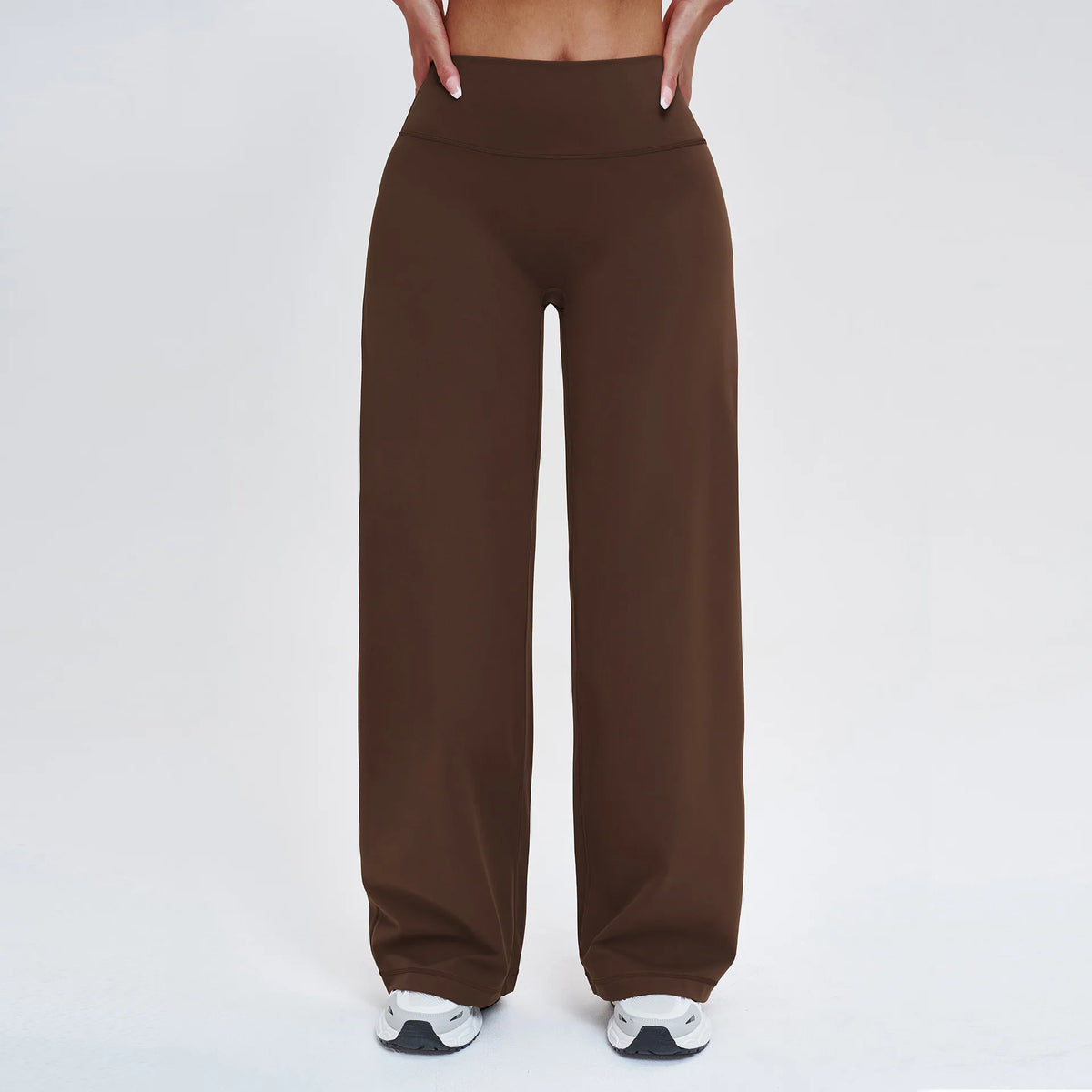 A pair of dark brown high-waist flared yoga pants worn by a person.