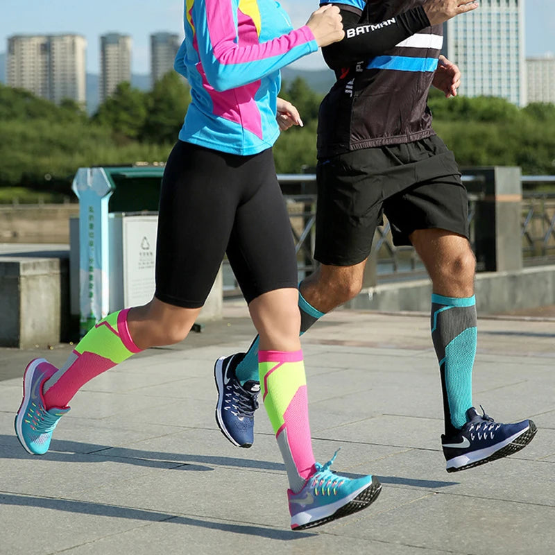 Two people running outdoors wearing brightly colored compression socks and athletic clothing.