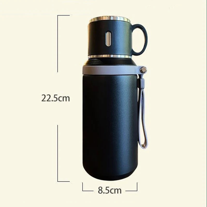 Bouteille de voyage en acier inoxydable isolé noire avec cap argenté et boucle de transport.