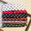 Stapel von Stoff-Polka-Dot-Haarbändern in verschiedenen Farben wie Weiß, Rot, Schwarz, Braun und Grün.