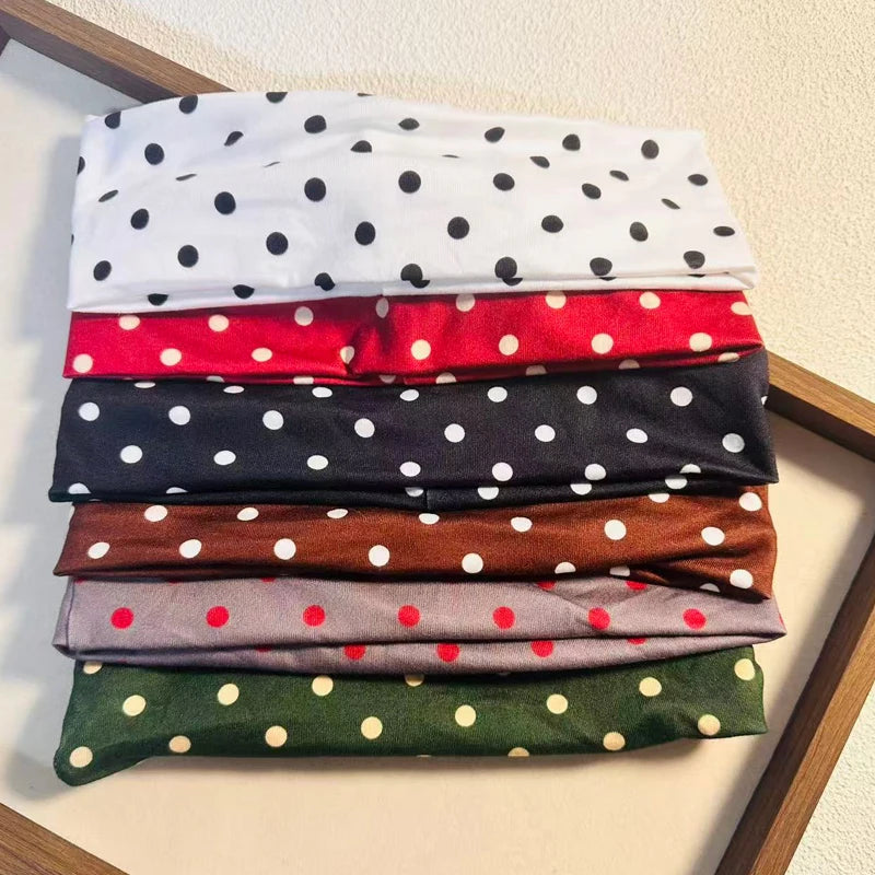 Stapel von Stoff-Polka-Dot-Haarbändern in verschiedenen Farben wie Weiß, Rot, Schwarz, Braun und Grün.
