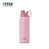 Tasse isotherme en acier inoxydable rose avec couvercle articulé sur fond blanc.