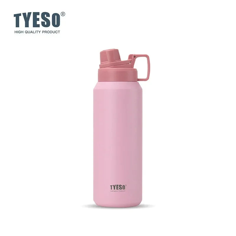 Tasse isotherme en acier inoxydable rose avec couvercle articulé sur fond blanc.