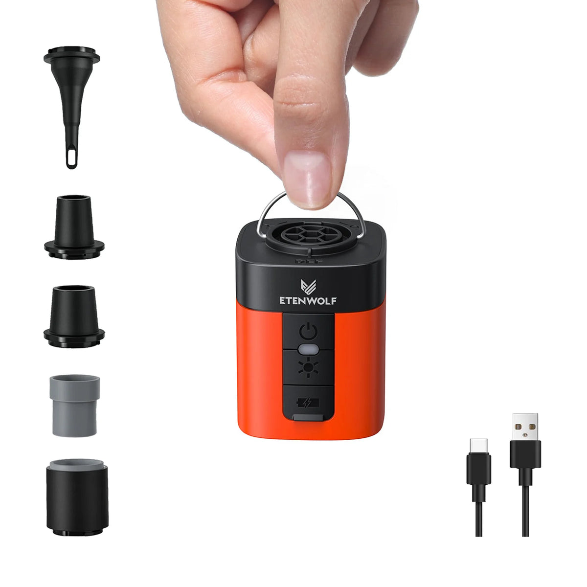 A hand holds an orange portable electric air pump device and several interchangeable nozzles.