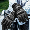 A pair of black heated thermal gloves being held by a person, ready for motorcycling or winter sports.