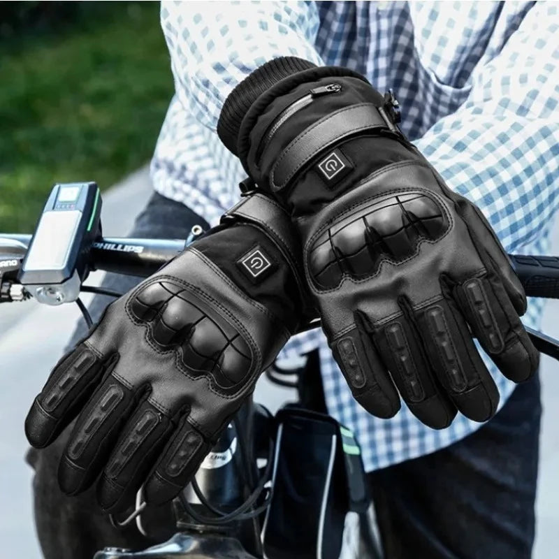A pair of black heated thermal gloves being held by a person, ready for motorcycling or winter sports.