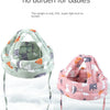 A pink and green soft adjustable safety helmet for toddlers displayed against a cloudy sky.