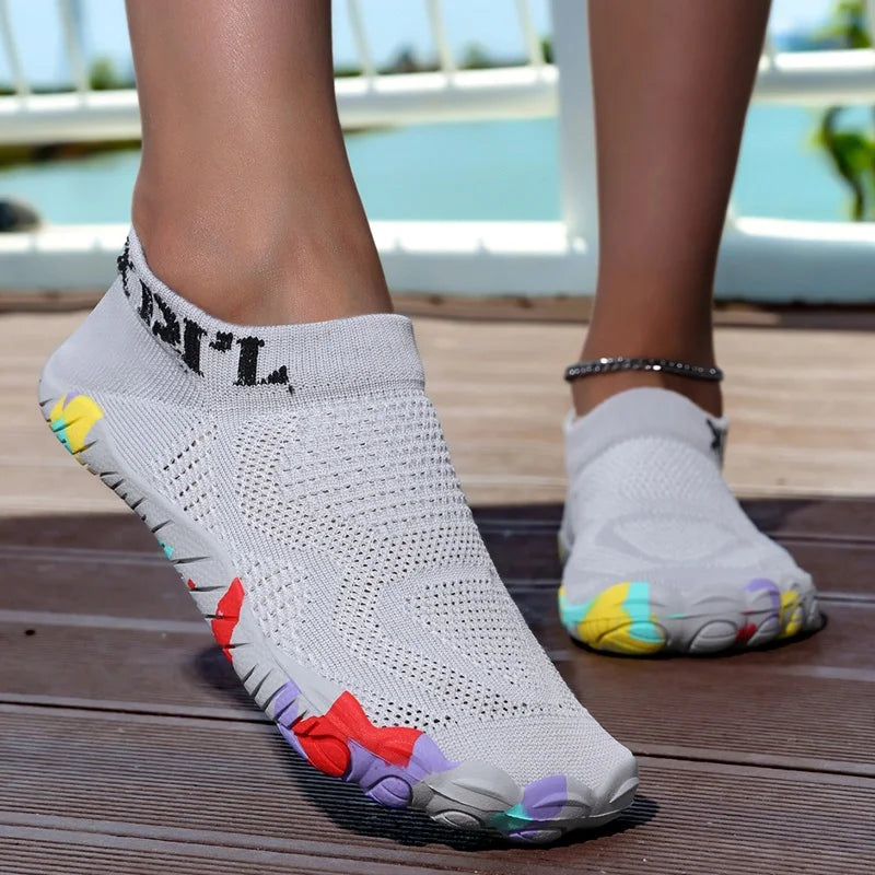 Gray waterproof quick-dry outdoor hiking shoes worn by a person on a wooden deck.