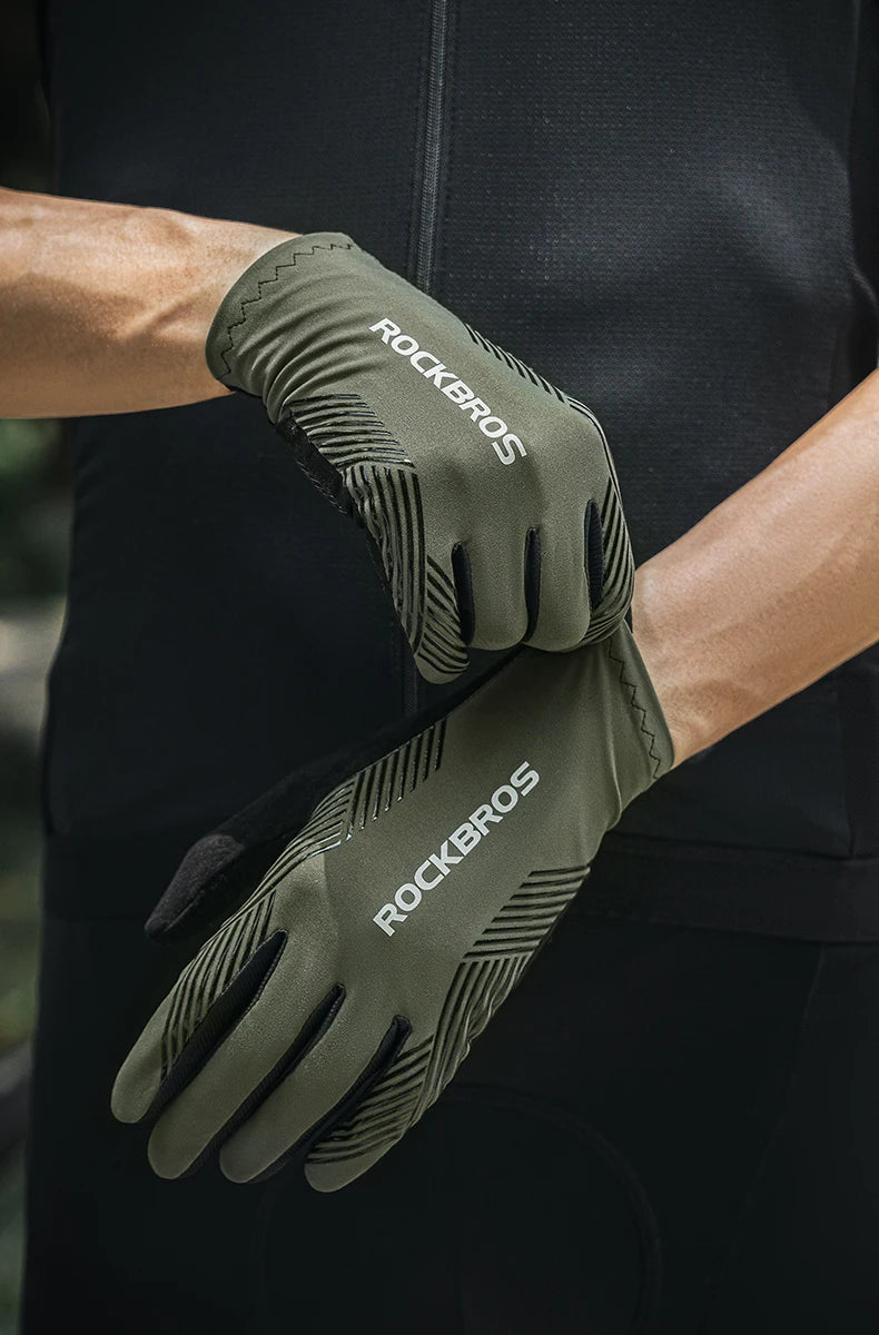 A close-up of olive green cycling performance gloves with ROCKBROS branding being worn on a hand.