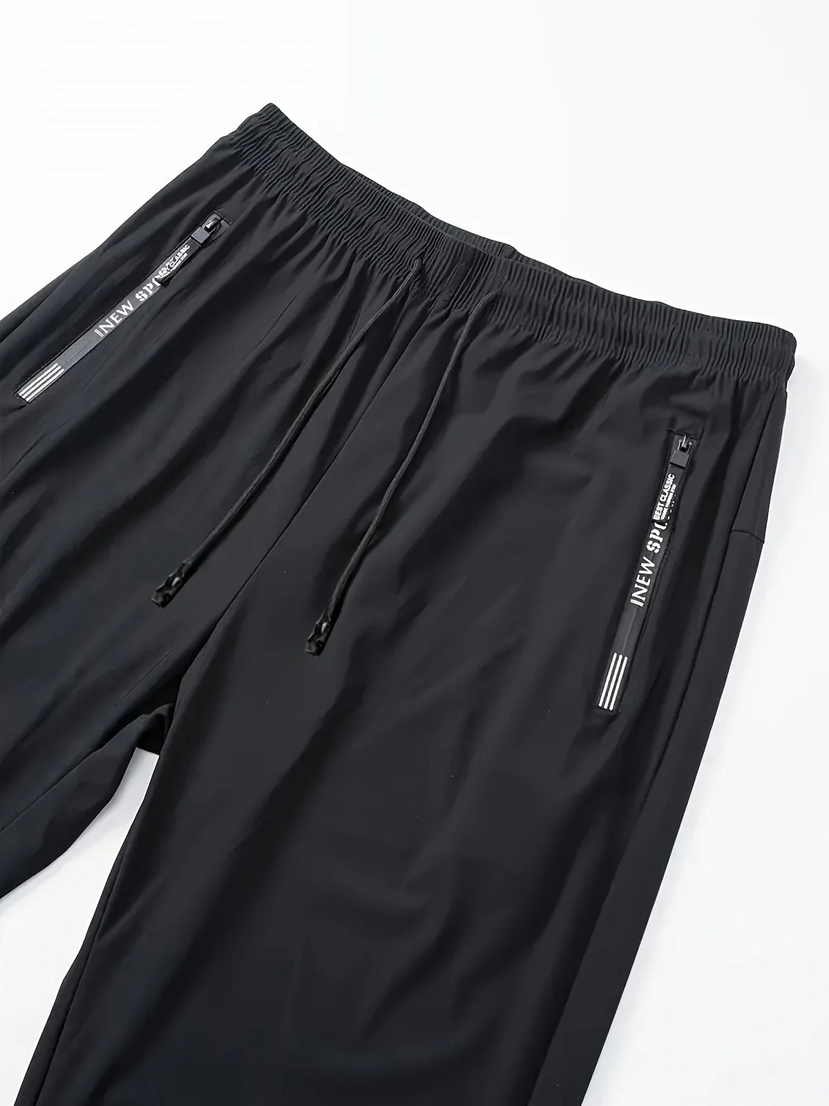 Black breathable men's casual jogger pants shown flat lay with a side pocket detail.
