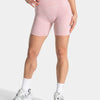 Pink leopard print seamless yoga shorts worn by a model, paired with white socks and athletic shoes.