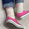 A pair of pink Converse sneakers worn with cream embroidered cotton socks.