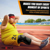A man wearing a yellow athletic shirt and shorts is sitting on a running track, demonstrating the use of a knee brace.