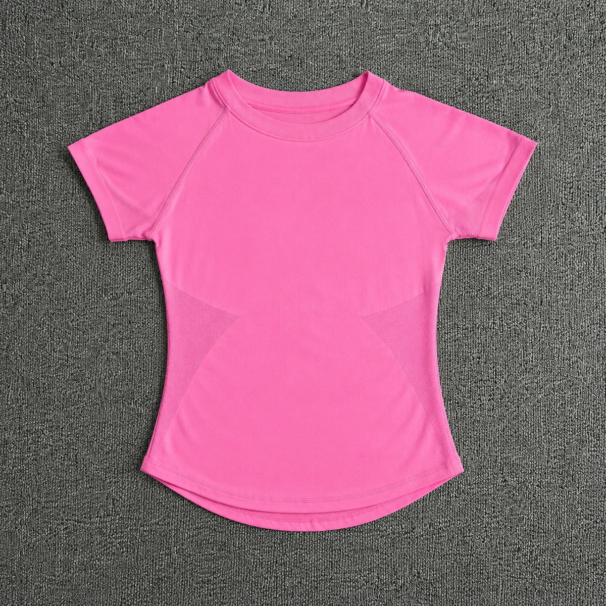 A bright pink seamless high-waist yoga top for women displayed against a dark gray textured background.