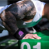 Une personne avec de nombreux tatouages utilise des bandeaux noirs pour l'entraînement de force.
