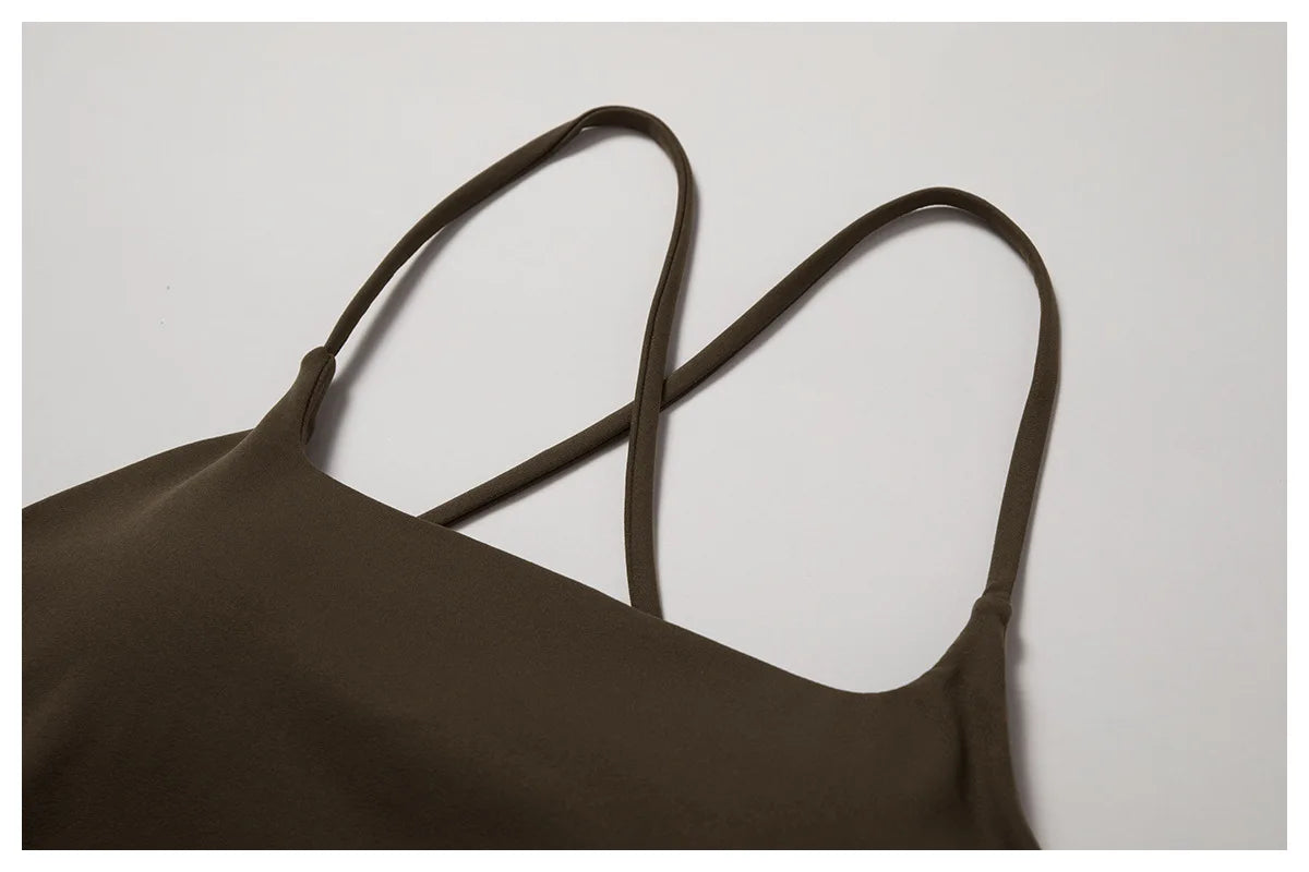 A close-up shot of a dark brown women's performance tracksuit top with thin straps.