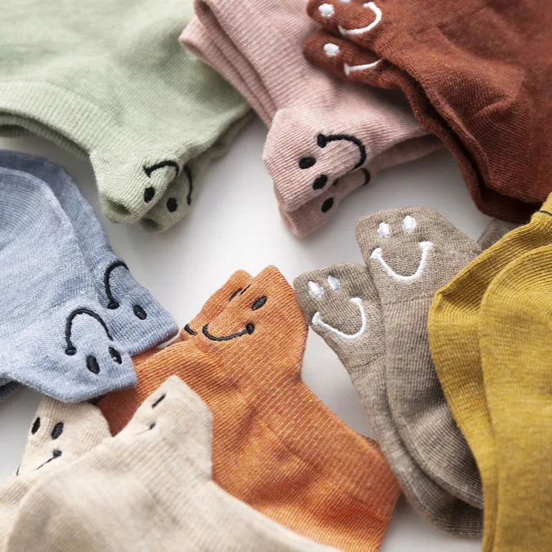 Colección de calcetines tobilleros con caras sonrientes bordadas en varios colores como verde, rosa, marrón, azul y amarillo