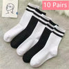 Ten pairs of black and white striped casual socks for men and women displayed on a light gray fabric.