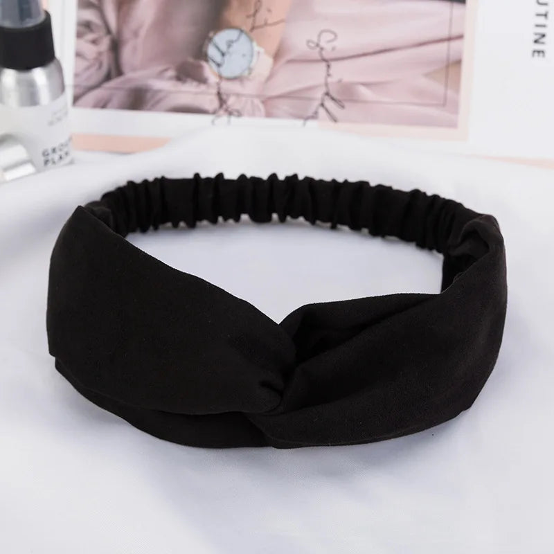 Black fabric headband or hair accessory shown flat on a white surface.