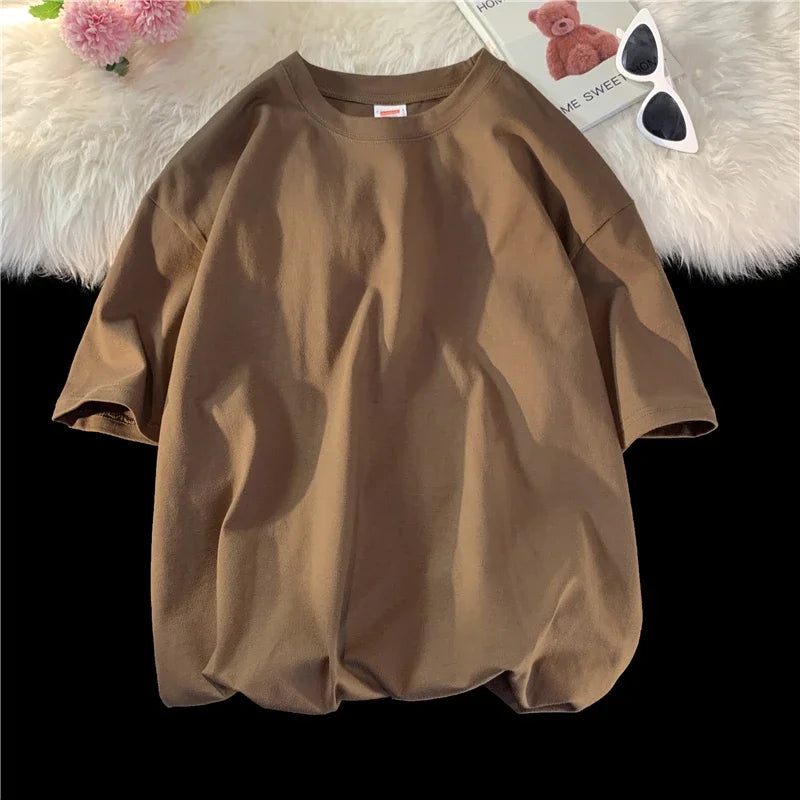 Lockeres, kurzärmeliges braunes Baumwoll-T-Shirt auf einer weißen flauschigen Oberfläche.