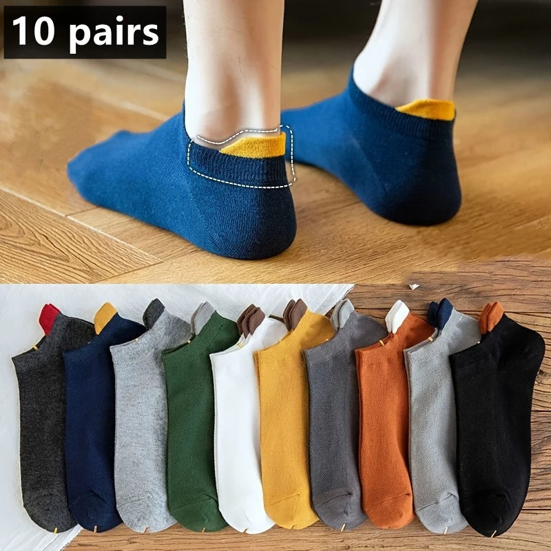 Eine Auswahl von zehn Paar Herrensocken aus Baumwolle in verschiedenen Farben auf einer Holzoberfläche.