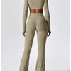A model wears a seamless, long-sleeved performance tracksuit set in beige, featuring a cropped top and matching full-length p