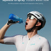 A cyclist is squeezing a blue spray bottle to create an instant water flow during cycling.