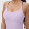A woman wearing a light purple women's athletic crisscross tank top.