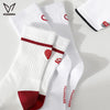 A stack of white crew socks with red accents and a logo design is displayed on a light surface.