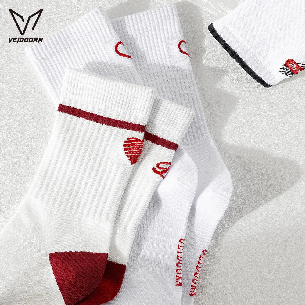 A stack of white crew socks with red accents and a logo design is displayed on a light surface.