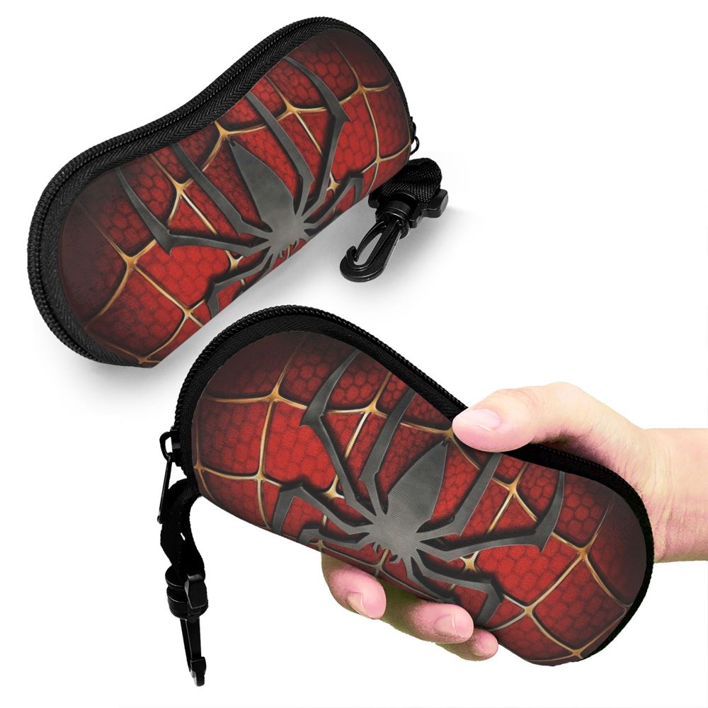 A black zippered pouch featuring a red and black spider web pattern, held in a hand.