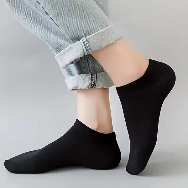 Black ankle socks worn by a person, paired with light gray pants.