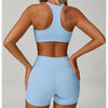 A woman models a light blue padded sport yoga bra and matching shorts from the back view.