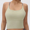 A model wearing a light olive green women's athletic crisscross tank top.