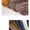 A close-up of various men's cotton crew socks in earthy tones including mustard yellow, brown, gray, and navy blue.
