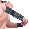 Black elastic wrist strap worn on a person's forearm for sports or daily support.