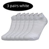 Three pairs of white performance running socks laid out side by side.
